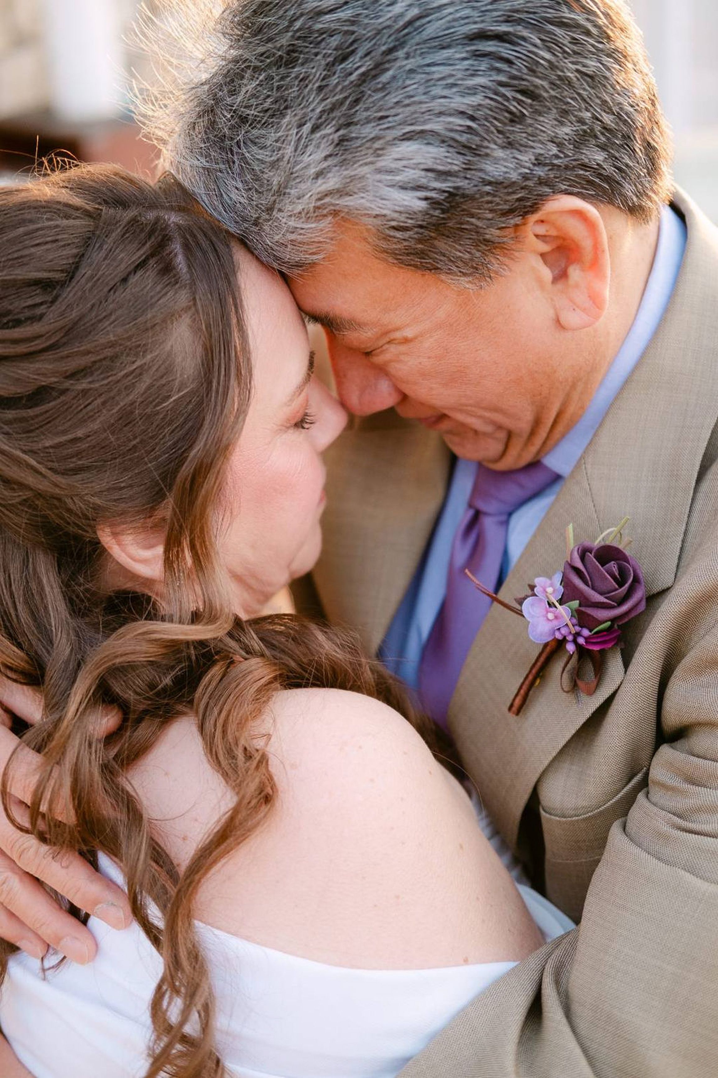 Emotional close-up of bride and groom sharing a tender embrace at a small wedding in Italy