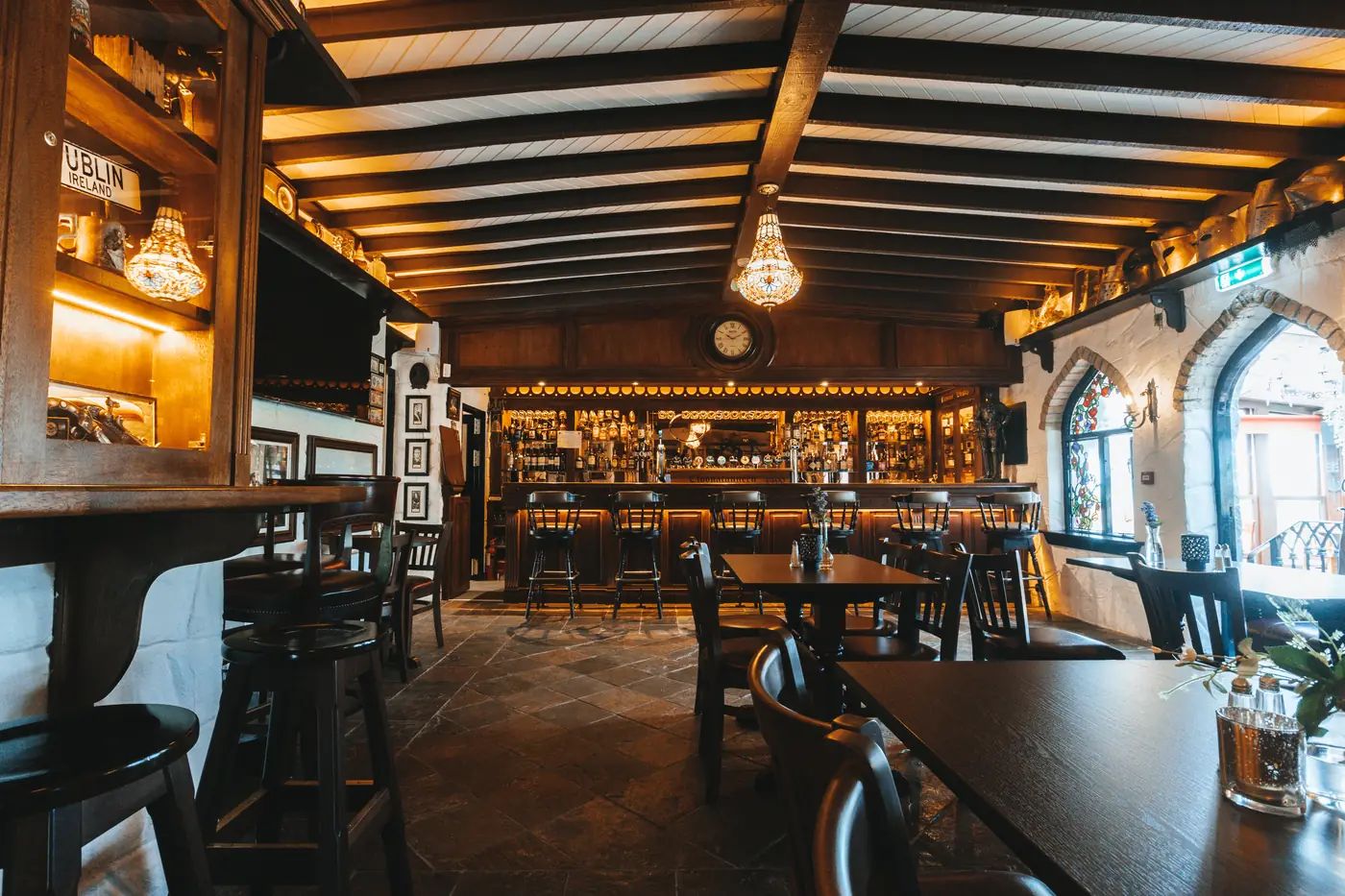 Bar 1490, the castle's own pub, with a beamed ceiling, long dark-wood bar, flagstone floor and stained-glass gothic windows.