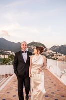 Bride looking at her groom during their destination wedding in Italy on a terrace with Amalfi coast in the background