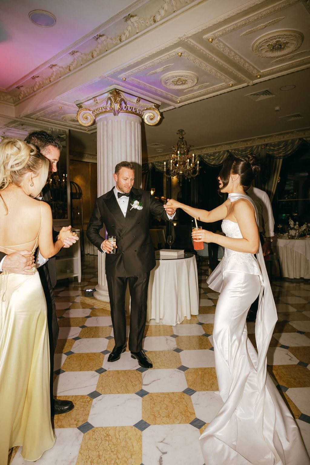 Family and friends dancing under chandeliers at an intimate wedding in Italy