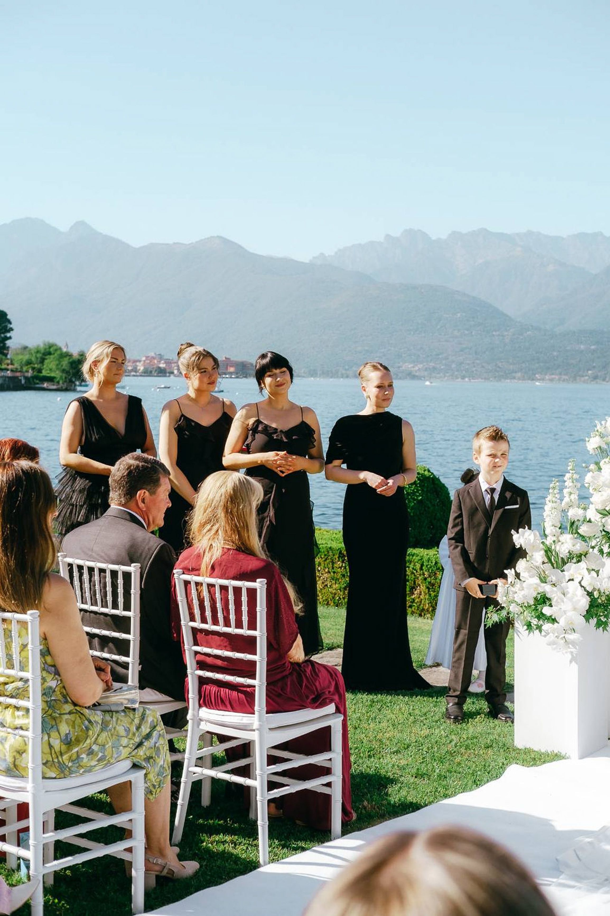 Bridesmaids and ring bearer standing by the lake during an intimate wedding in Italy ceremony