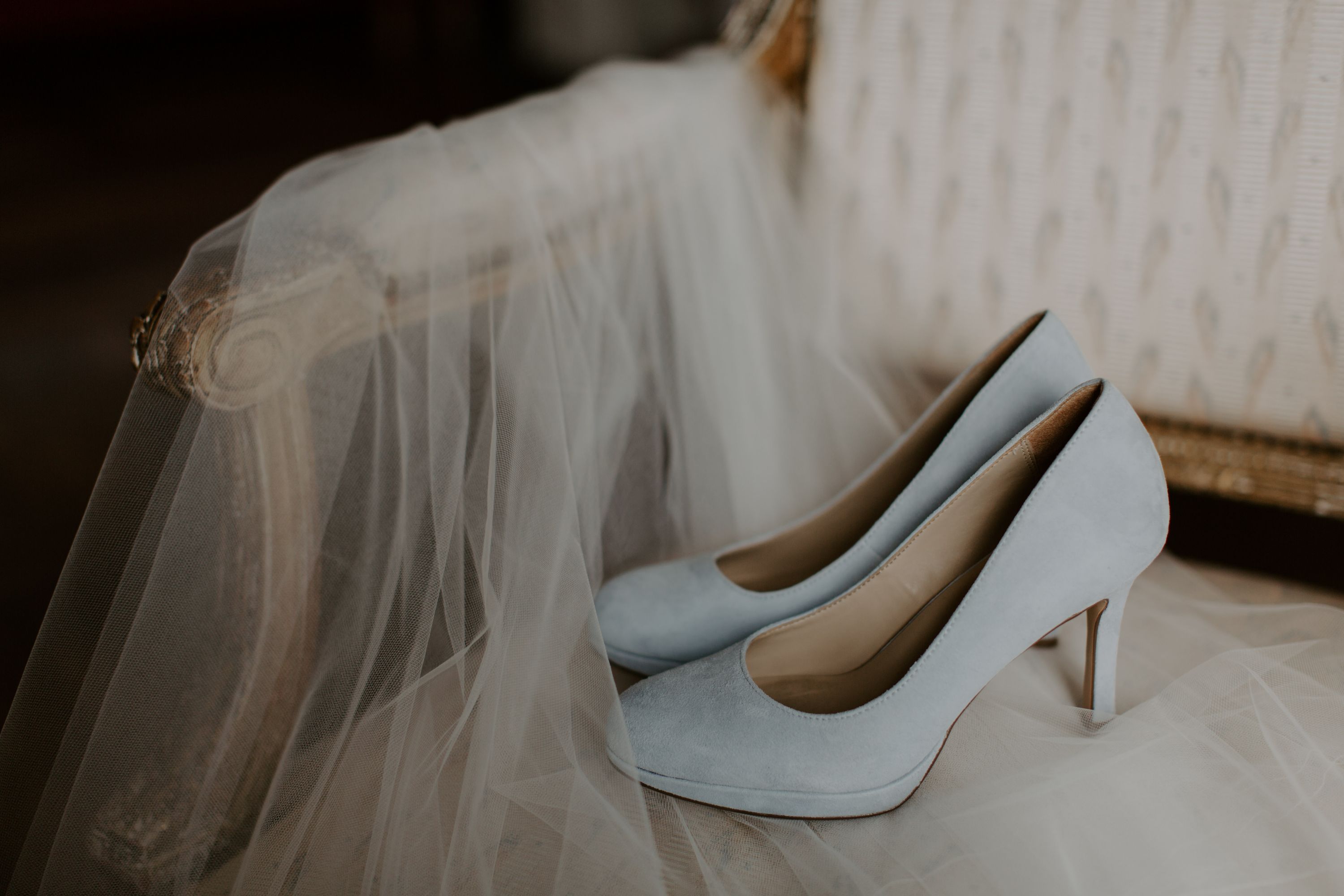 Blue shoes on a white wedding veil