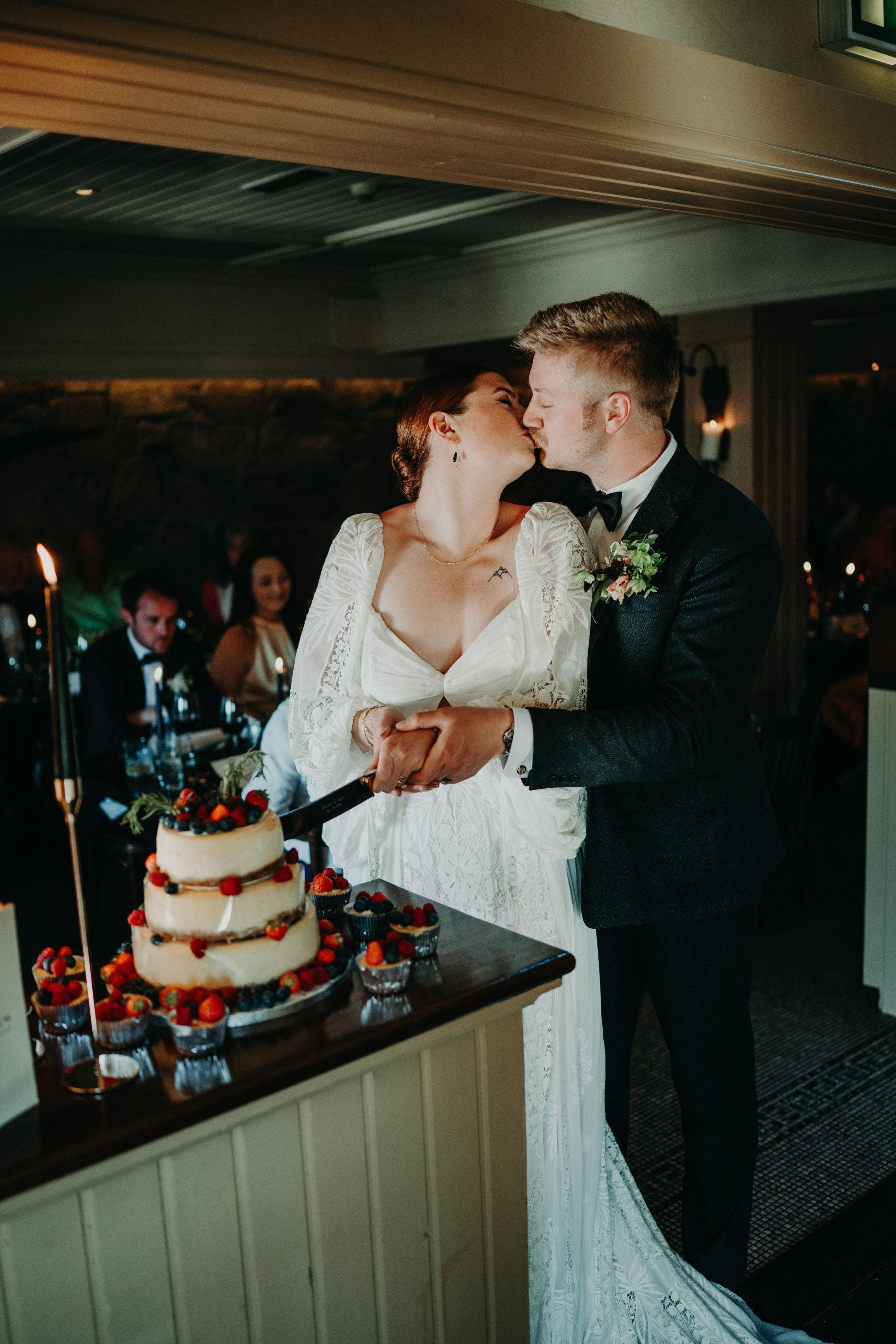 A bride and groom cutting a cake during a reception after their small wedding in Ireland