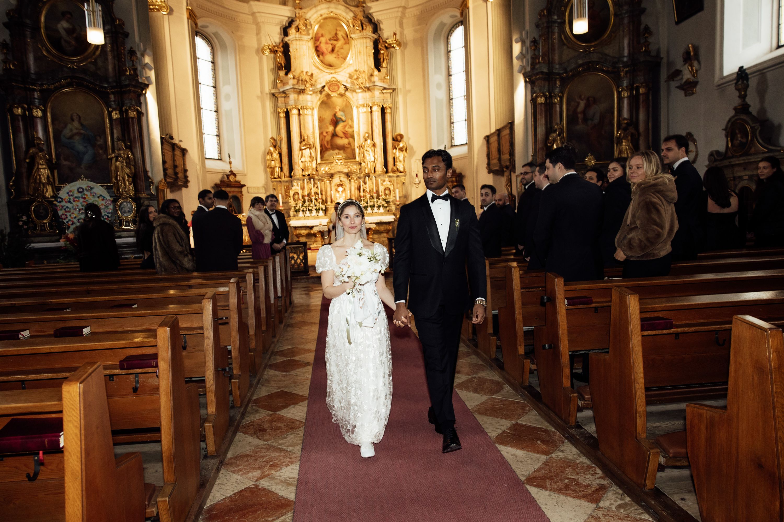 Bride and groom walk down the church aisle after their ceremony at a small wedding in Austria