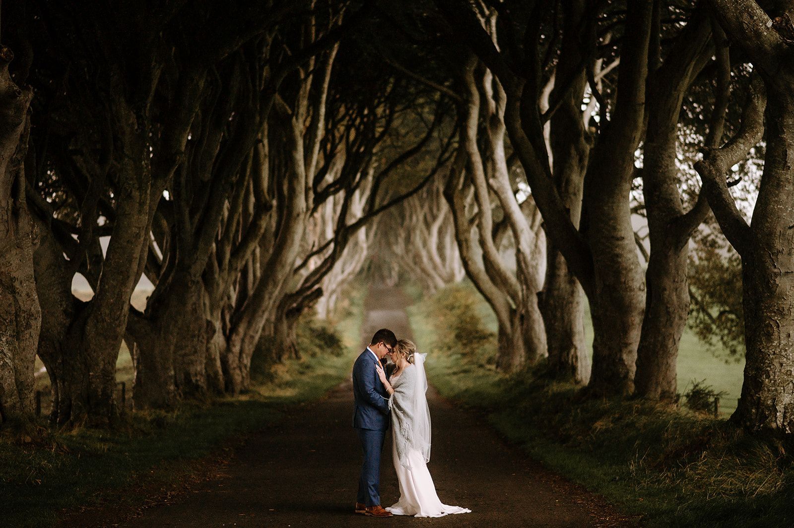 Bride and groom posing at The Dark Hedges on their wedding day in Ireland
