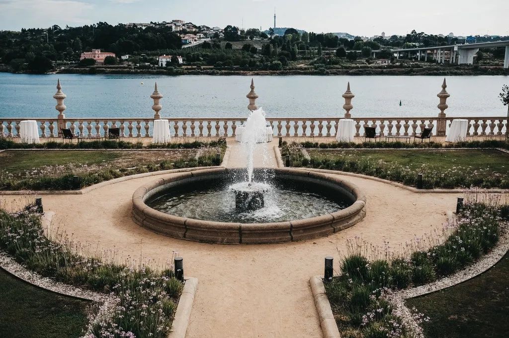 A working fountain in the middle of a formal garden of a wedding venue in Portugal, overlooking a river