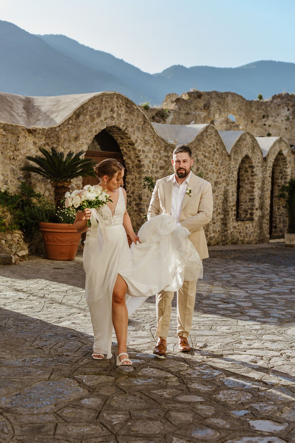 Newlyweds having a photoshoot at the cobbled street of an ancient Amalfi hotel during their elopement in Italy