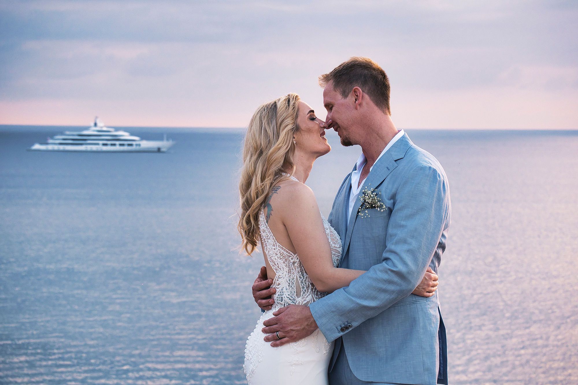 Bride and groom celebrate elopement in Spain atop a cliff in Ibiza with the Balearic Sea in the background