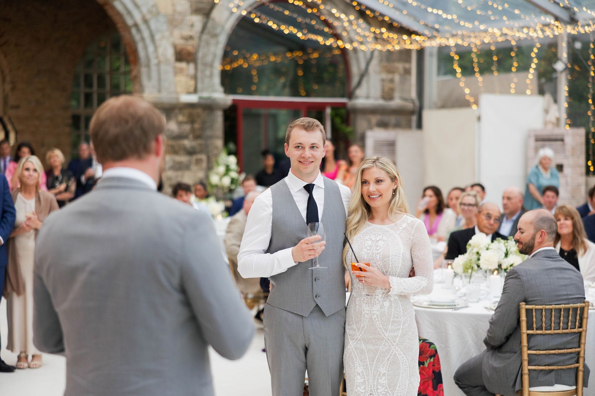 Newlyweds listen to a speech during the reception of their destination wedding in Portugal
