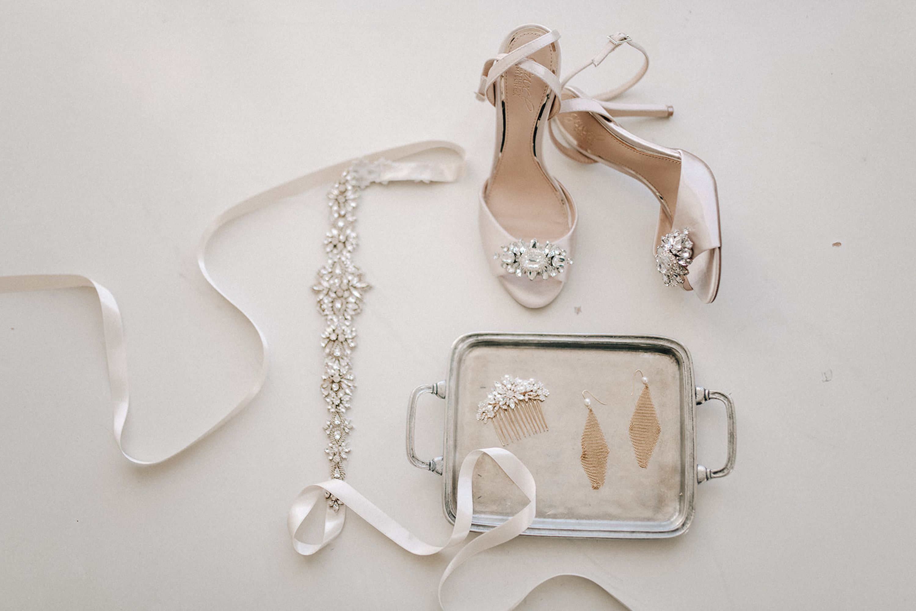 Bridal shoes, crystal belt, and accessories arranged for a small wedding in Italy with elegant minimalist styling