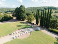 Outdoor wedding ceremony in Tuscany, Italy with lush greenery, rolling hills, and tall trees in the background