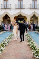 Bride and groom dance in casual attire at a farmhouse in front of their guests during their small wedding in Spain