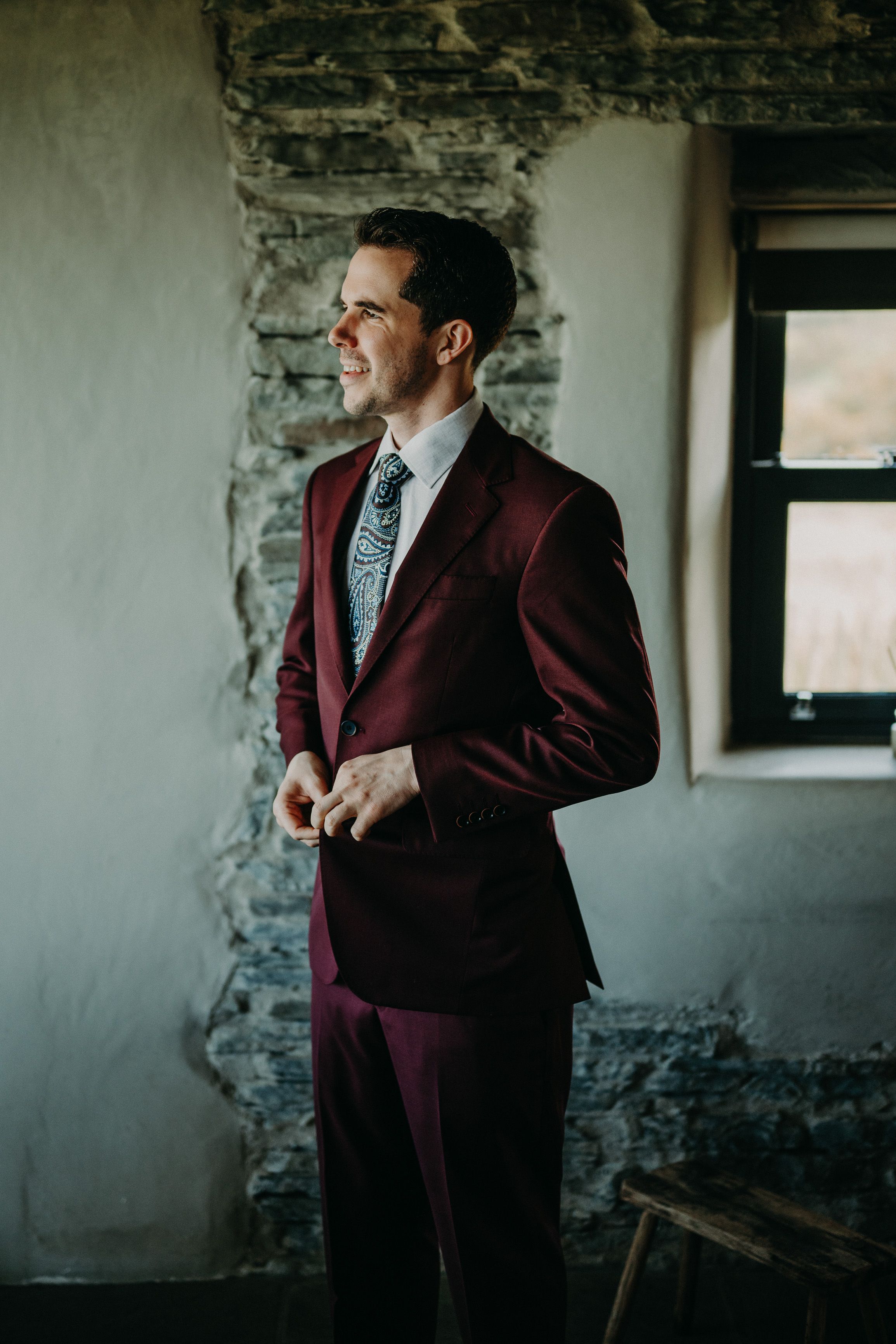 A groom preparing inside a cottage ahead of his small wedding in Ireland