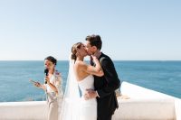 Newlyweds kissing on the cliffs of Algarve during the ceremony of their elopement in Portugal