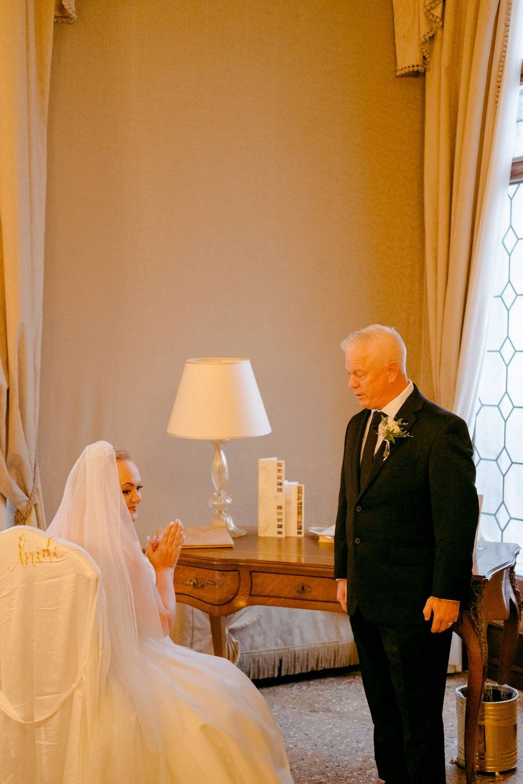 Bride and groom looking at each other inside a hotel room as they got ready to renew vows in Italy