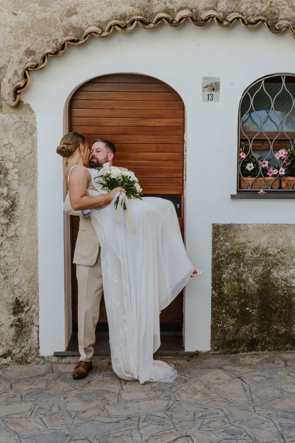 Bride and groom are about to kiss in front of a rustic house in Amalfi during the photoshoot of their elopement in Italy
