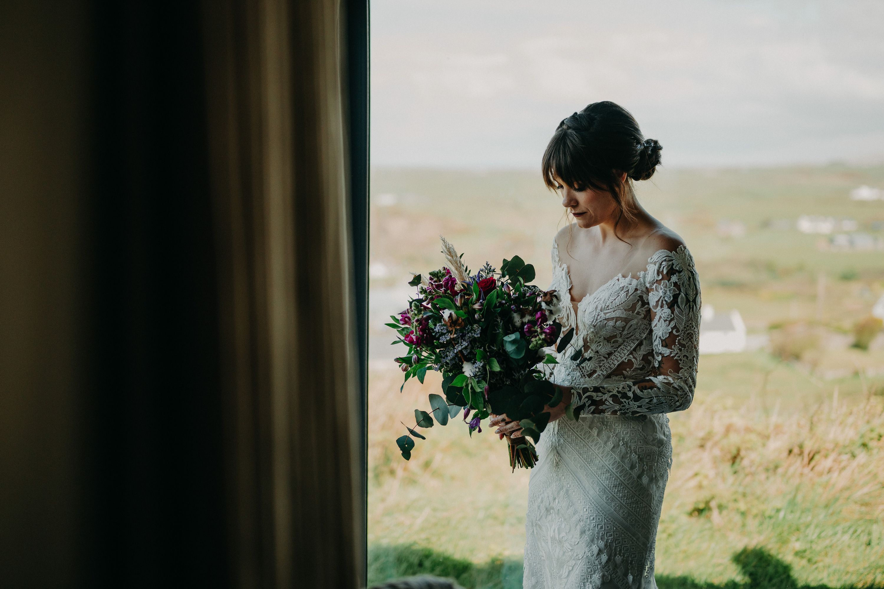 A bride inspecting her lovely bouquet before her intimate wedding in Ireland
