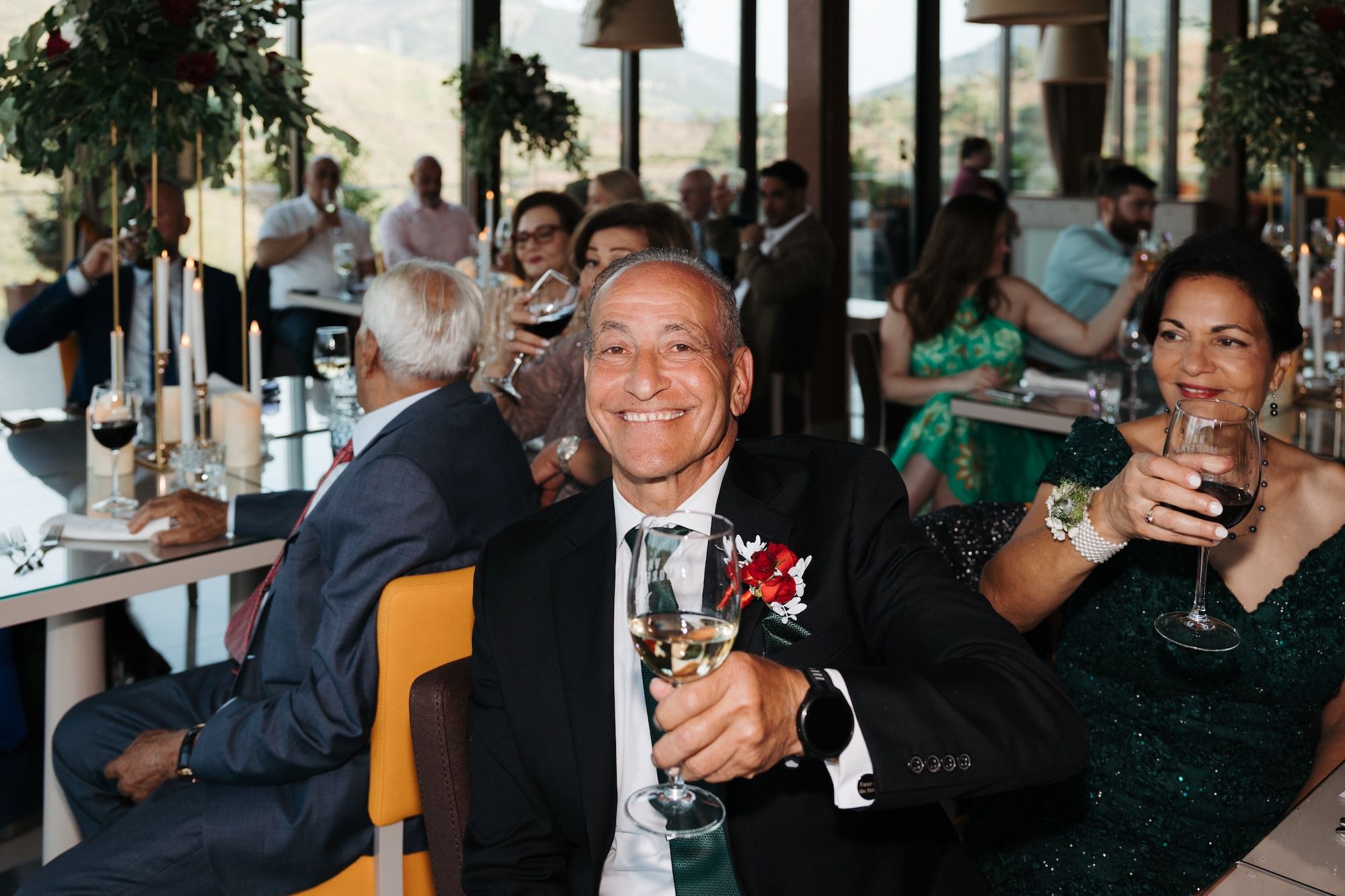 Guests smile while holding wine glasses during the reception of an intimate wedding in Portugal
