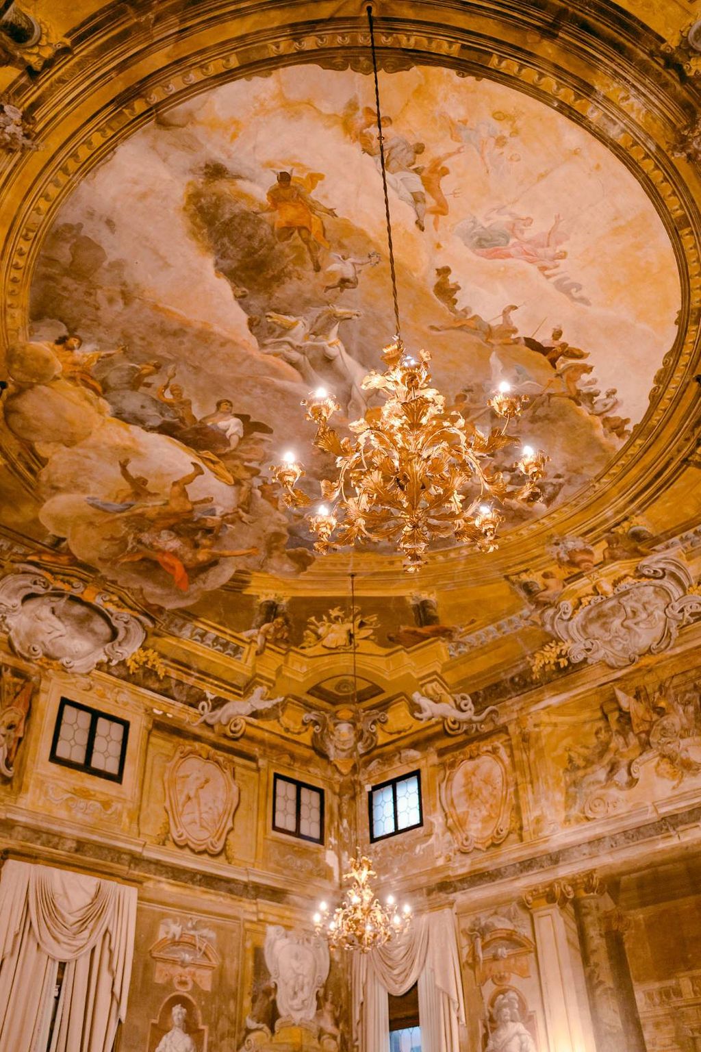 Stuccoed ceiling with chandeliers of a national monument and museum in Venicel, Italy