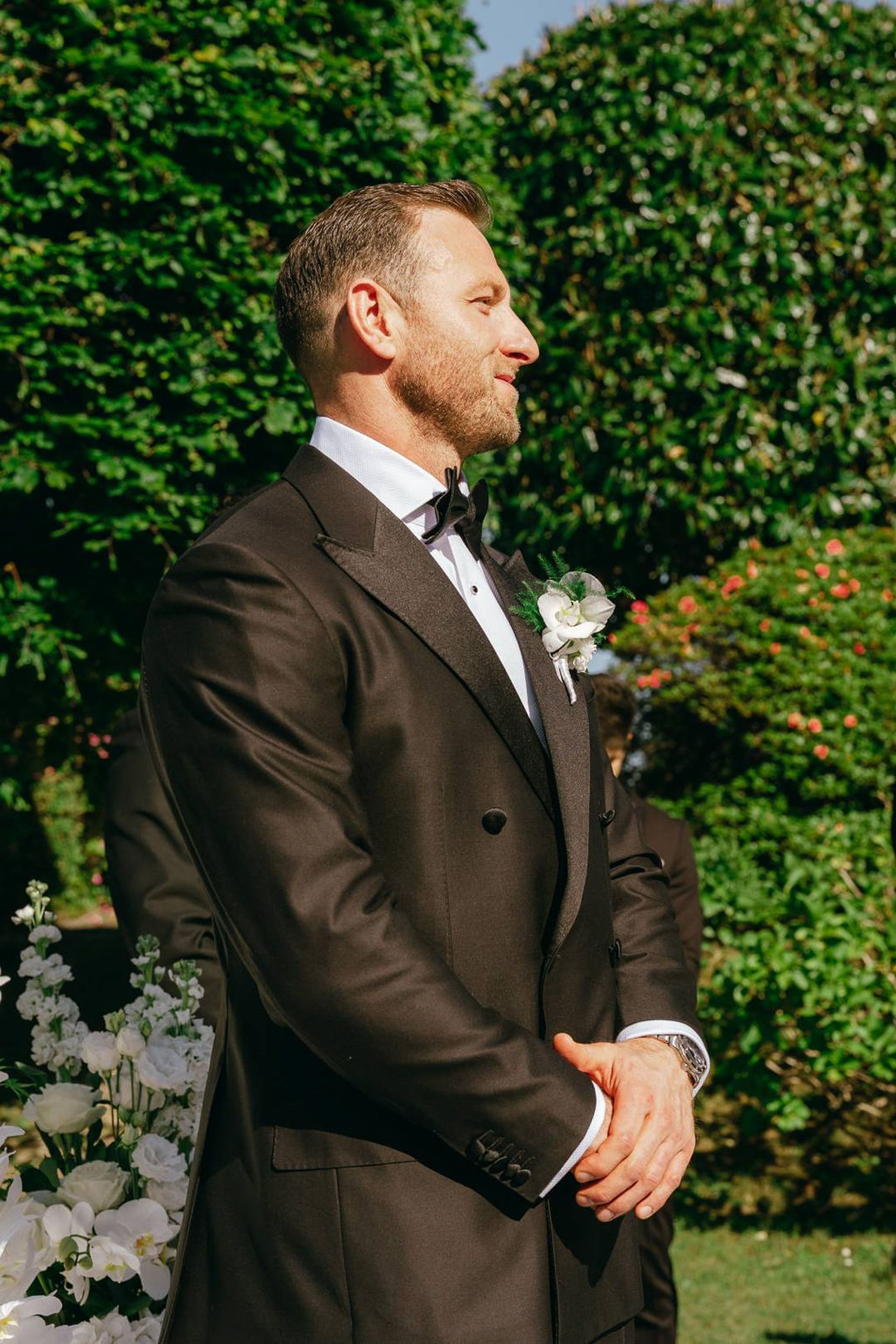 Groom waiting at the ceremony in a black tuxedo during a small wedding in Italy