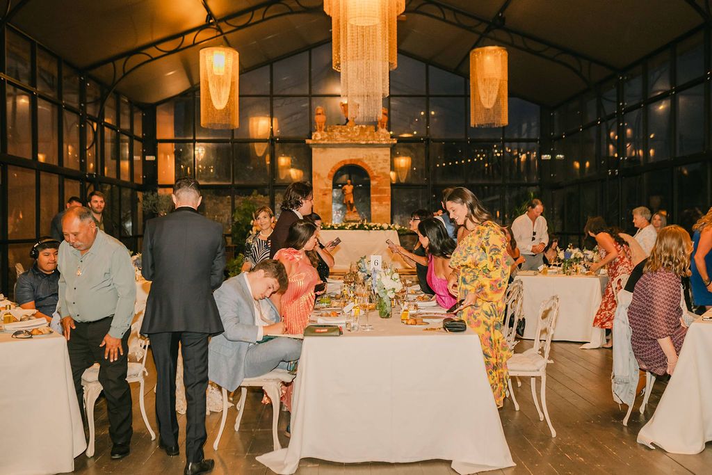 Wedding guests on the table during an evening reception of a destination wedding in Italy at Tuscany