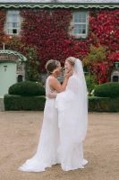 Two brides holding each other during their first look for their small wedding in Ireland