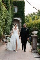 Newlyweds hold hands and walk on the palace's terrace during their small wedding in Portugal