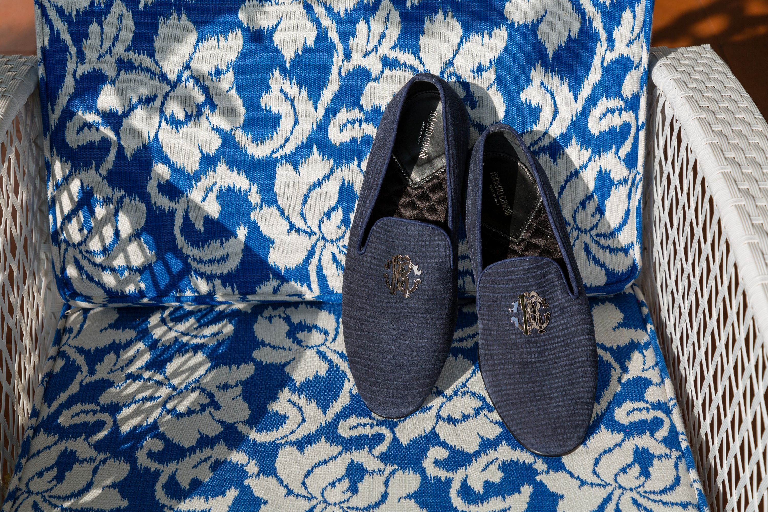 A pair of blue shoes placed on top of a cushioned chair