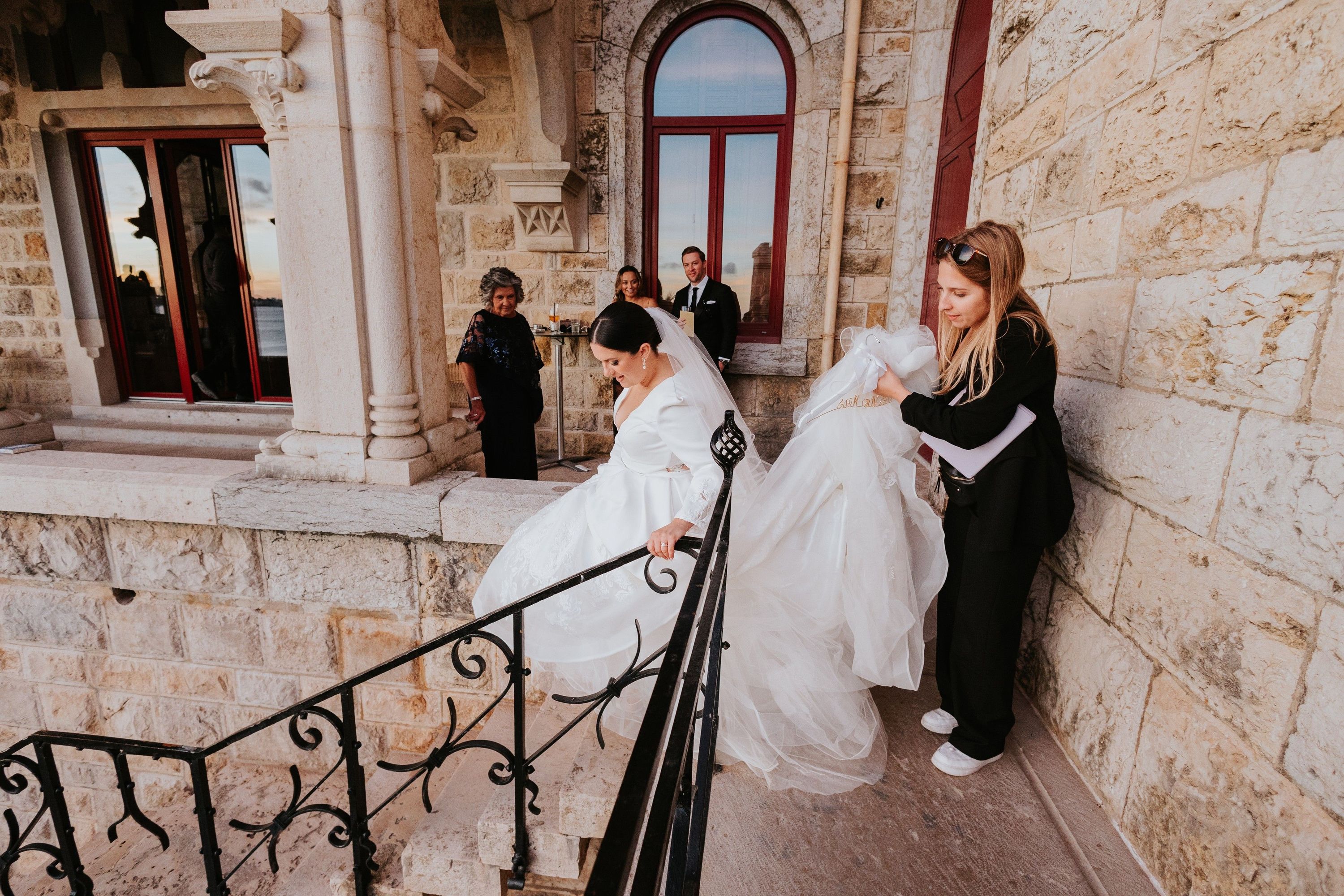 Destination wedding planner in Portugal holding a bride's dress train