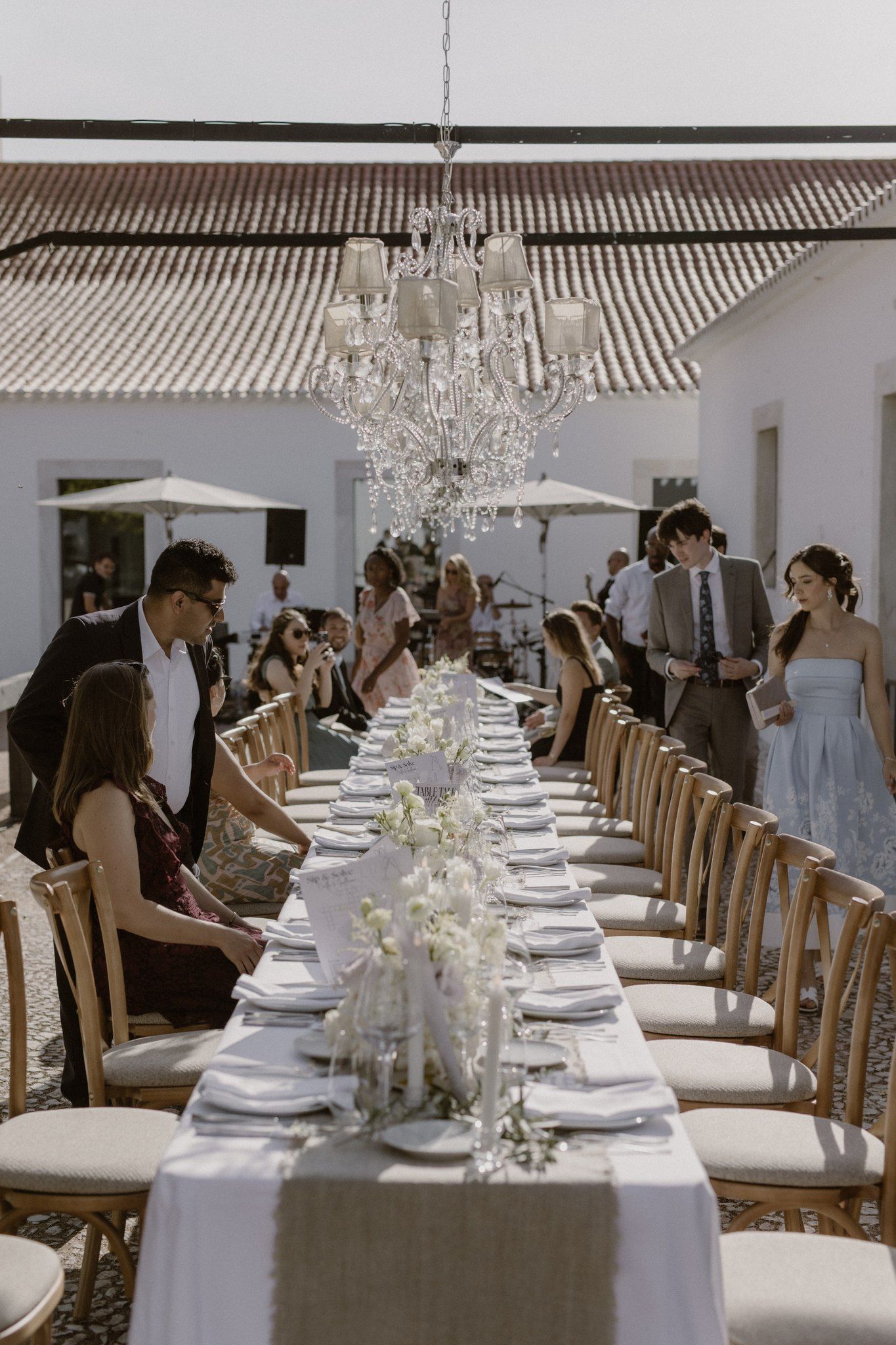 Guests arrive at the outdoor reception with a long table arranged for a micro wedding in Portugal