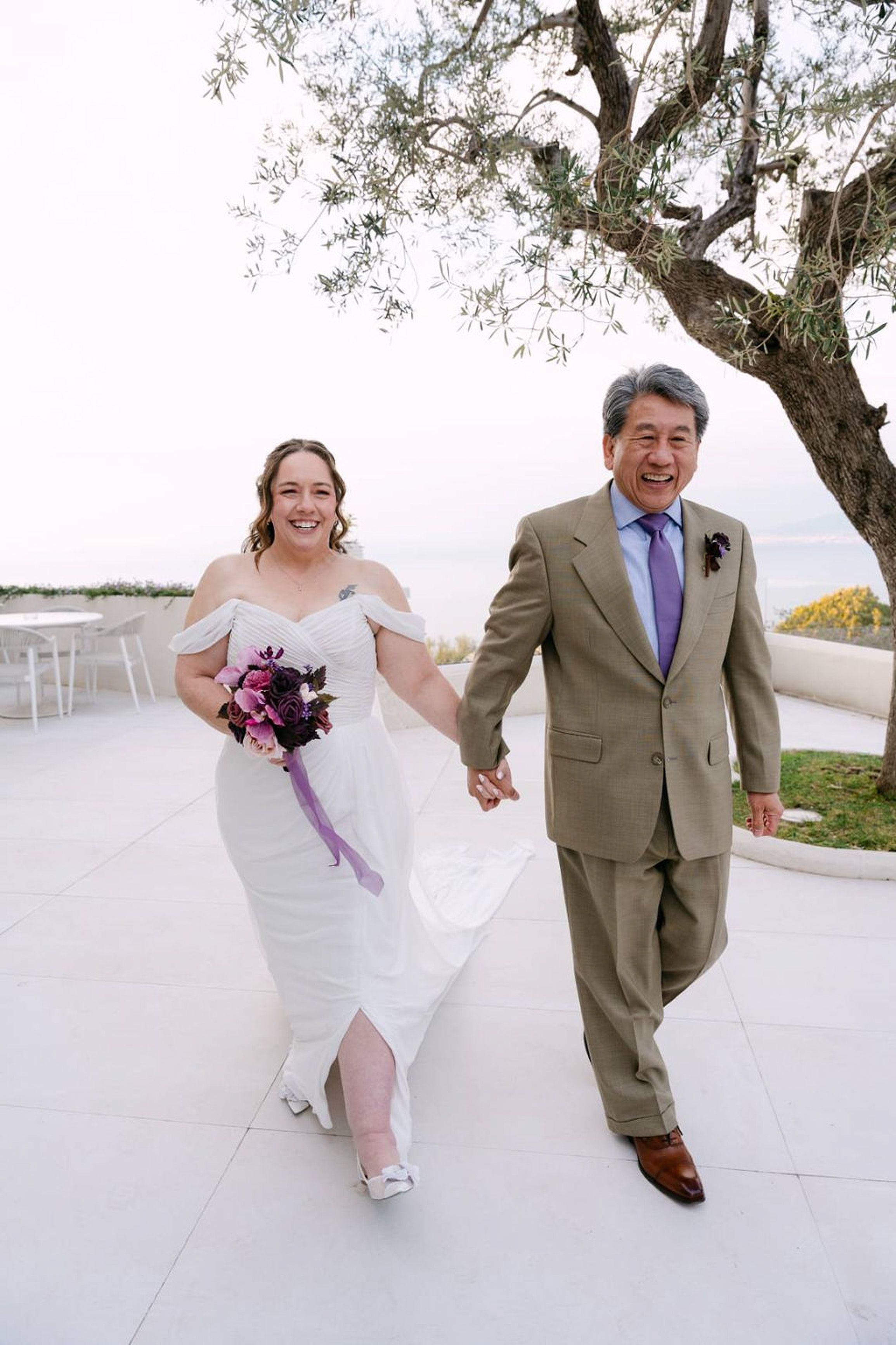 Happy newlyweds walking hand in hand after an intimate wedding in Italy with sea views