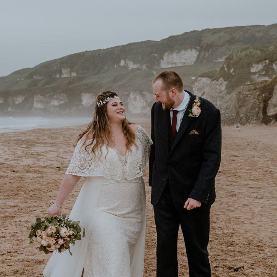 Bride and groom walking on a beach at their destination wedding in Ireland