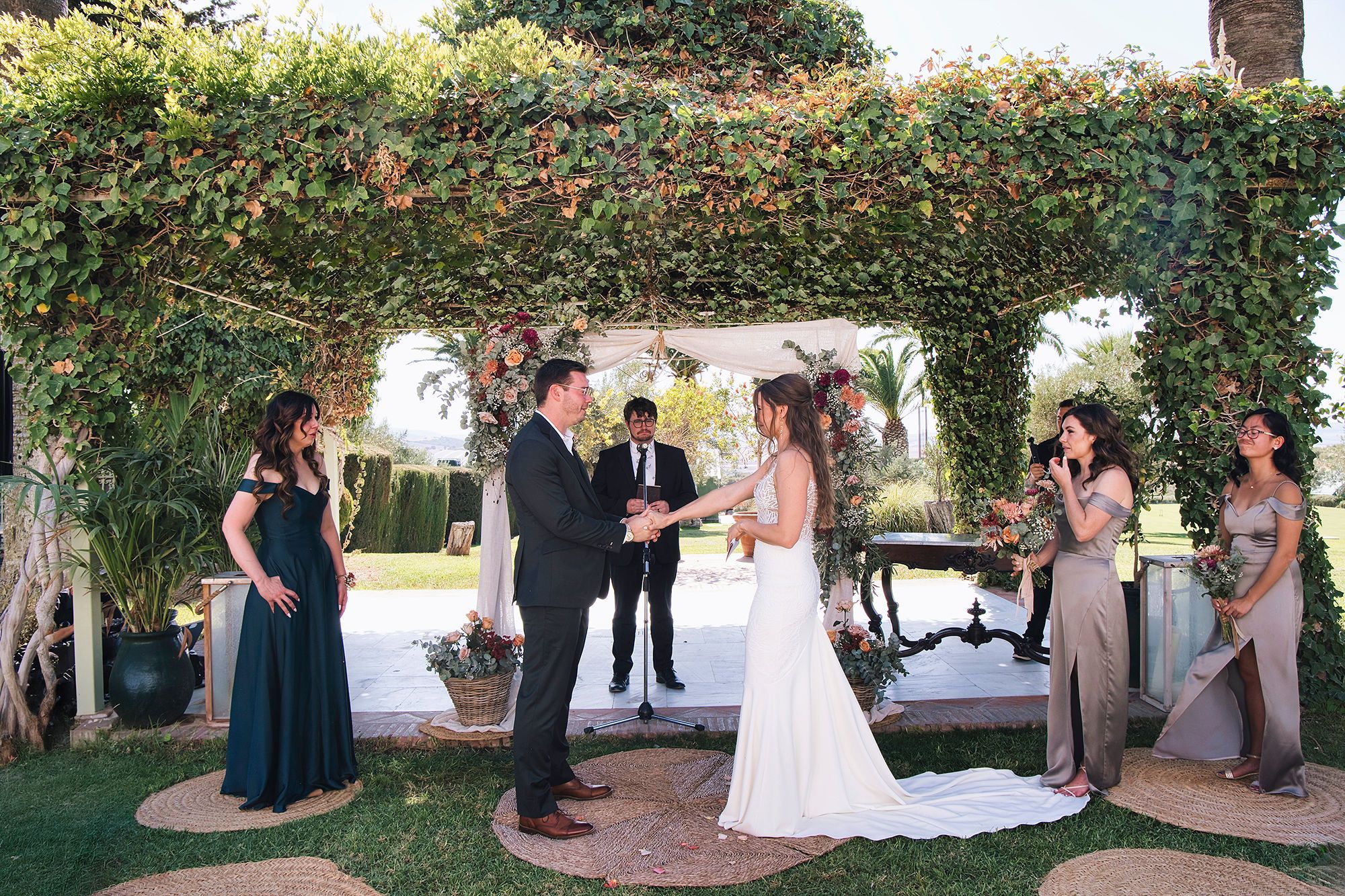 An outdoor ceremony under a pergola in the garden of a farmhouse in Cadiz where they got married in Spain