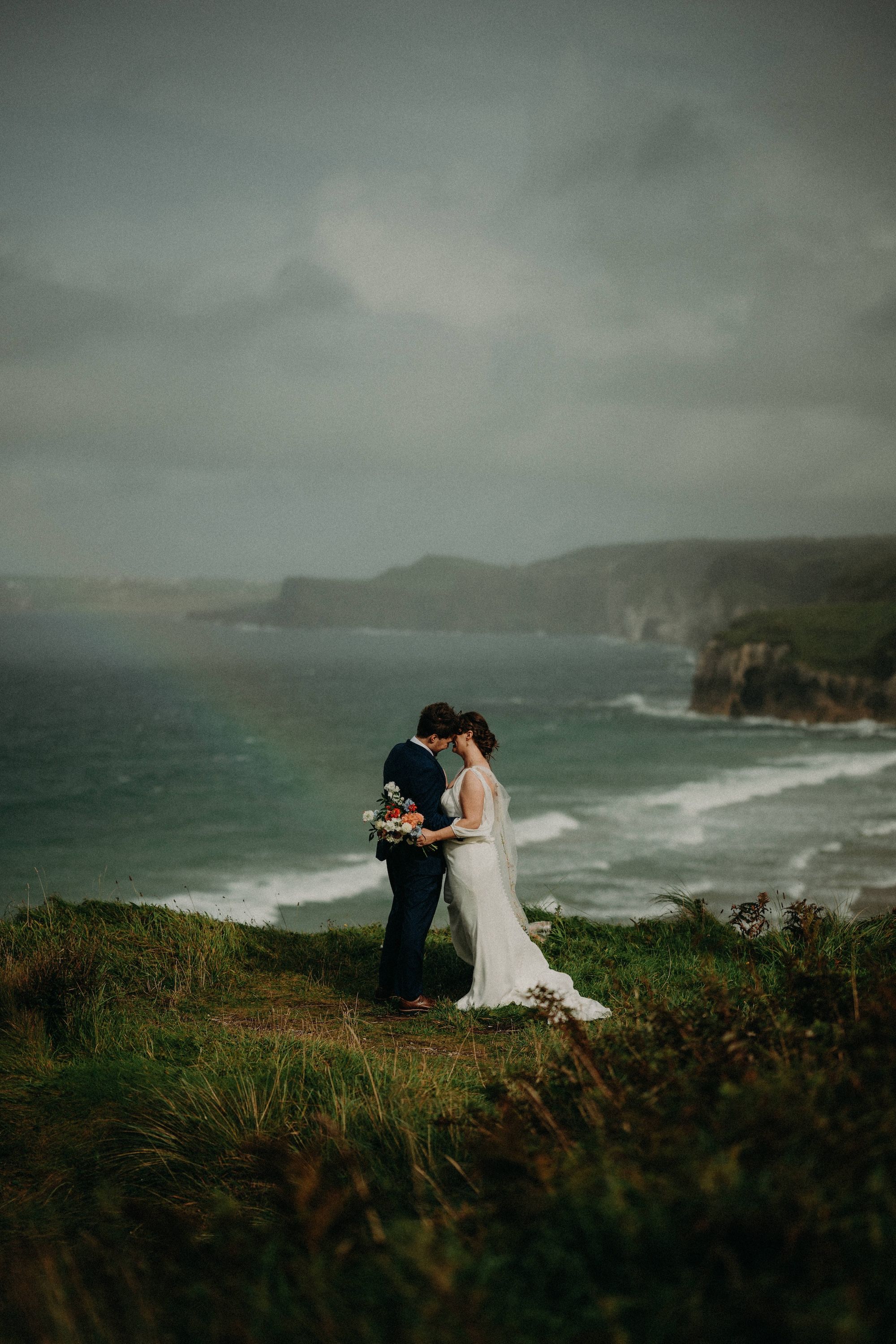 Bride and groom atop the cliffs of Antrim during their micro wedding in Ireland during autumn.