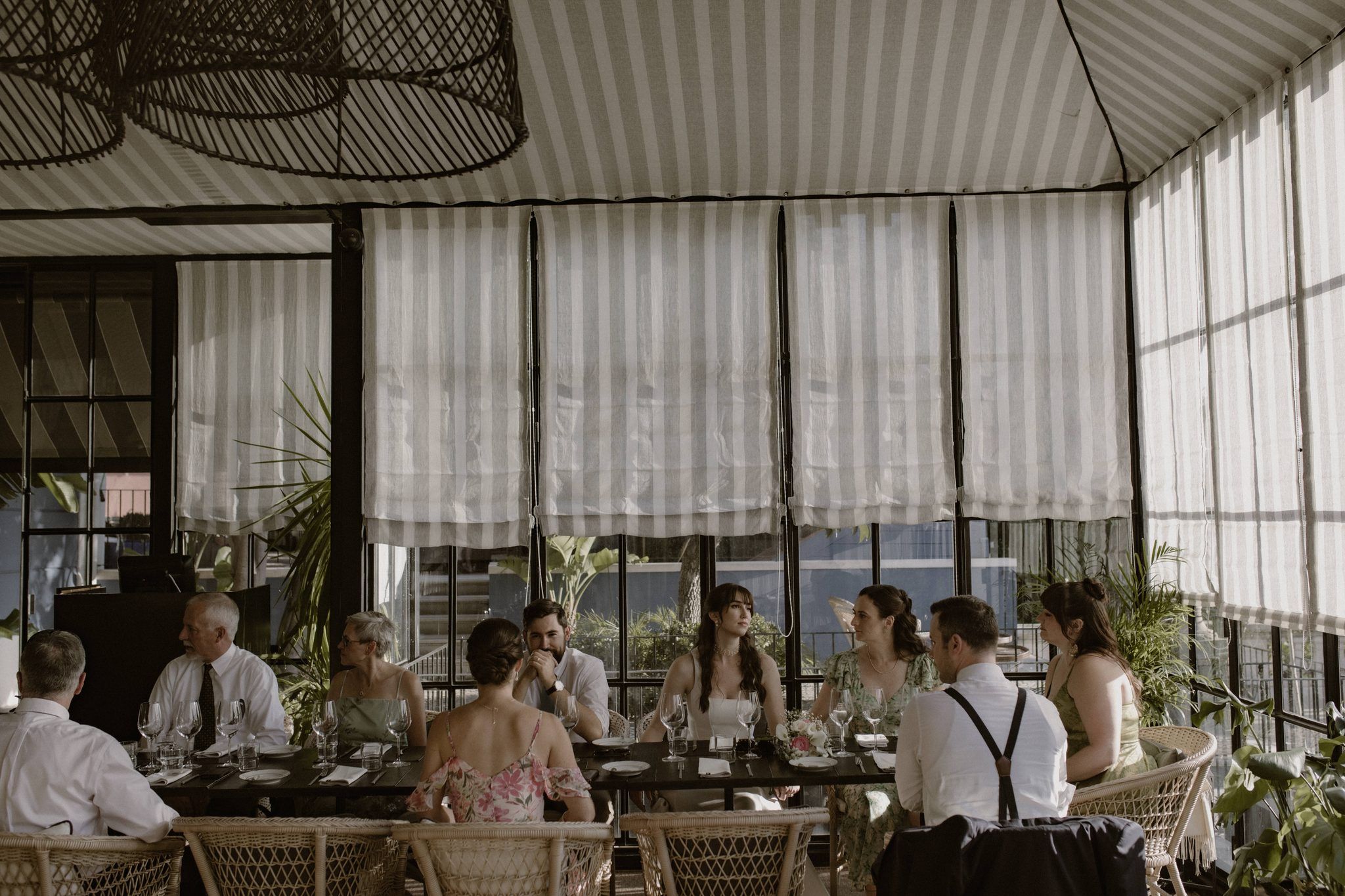 Bride and groom are having dinner with their guests in a palace hotel in Lisbon during their micro wedding in Portugal