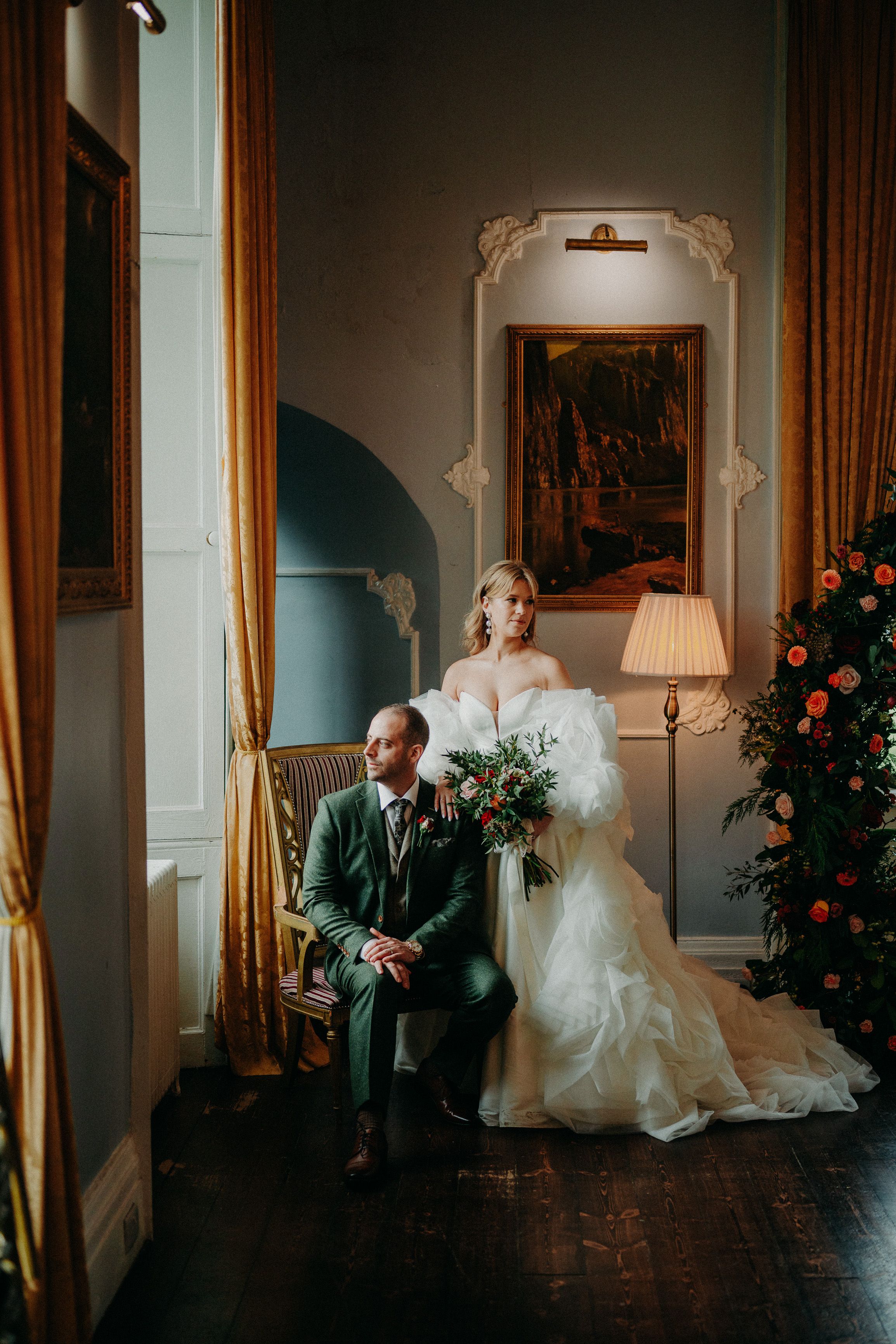 Elegant bride and groom portrait inside a castle with floral ceremony backdrop from an intimate wedding in Ireland