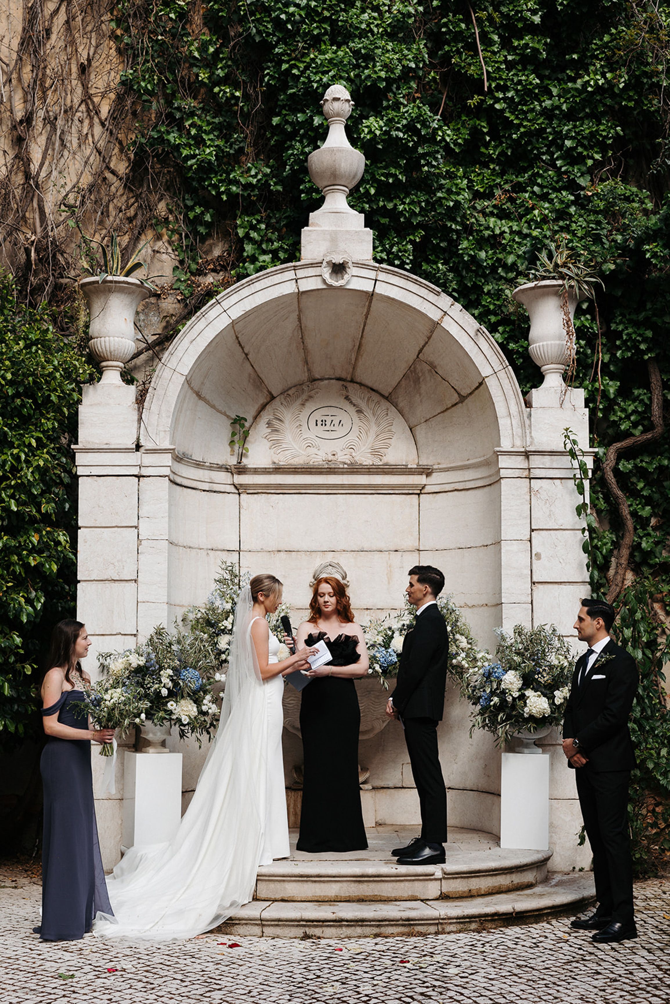 Elegant outdoor ceremony framed by ivy-covered walls during an intimate wedding in Portugal