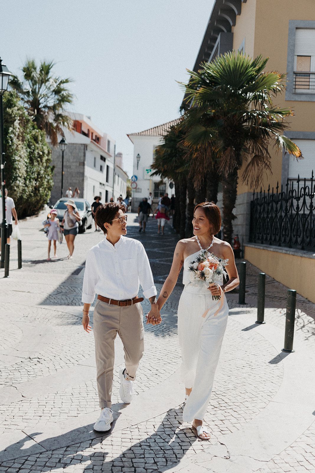 Couple walking along a street with buildings on the side during their summer small wedding in Portugal