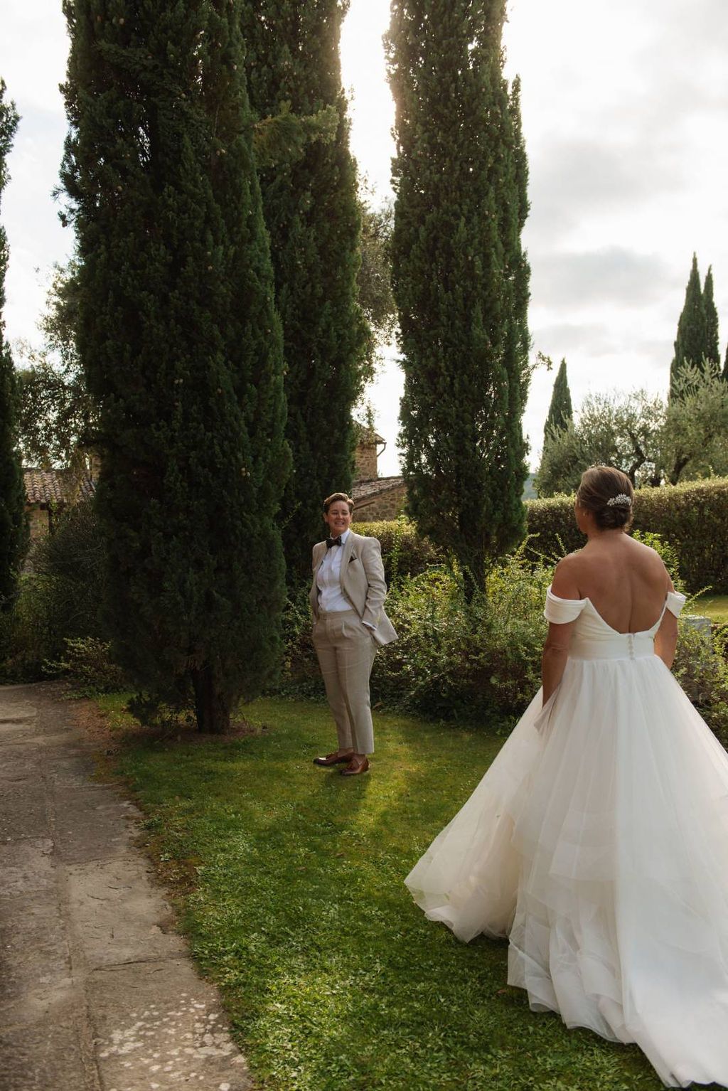  Bride and groom having their first look outdoors surrounded by trees in a Tuscan estate where they got married in Italy