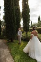  Bride and groom having their first look outdoors surrounded by trees in a Tuscan estate where they got married in Italy
