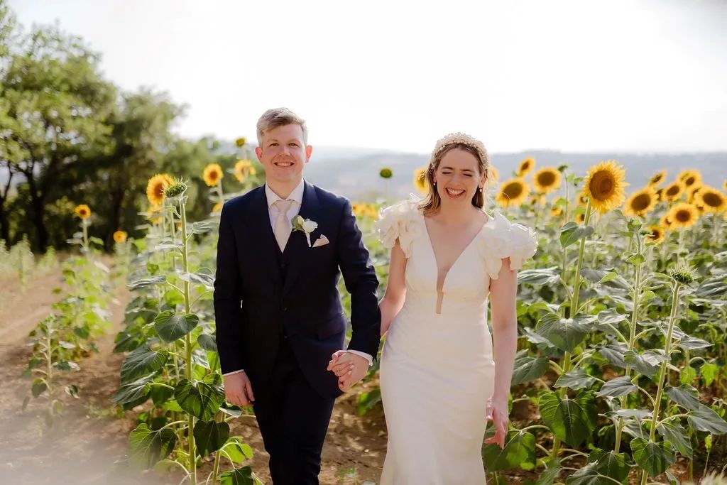 Happy newlyweds in the middle of a sunflower field in Umbria during their destination wedding in Italy