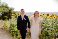 Happy newlyweds in the middle of a sunflower field in Umbria during their destination wedding in Italy