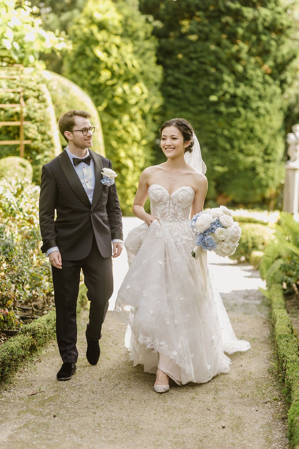 A bride and groom walking down a garden path during their small wedding in Switzerland