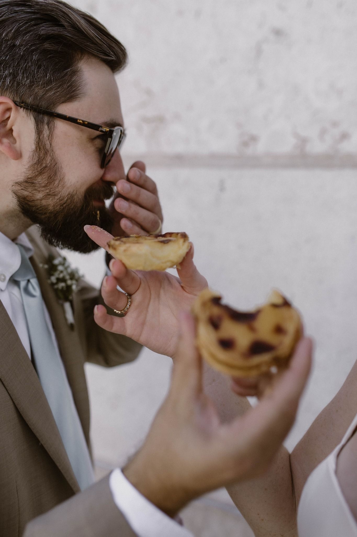 Bride and groom eating pastéis de nata and laughing