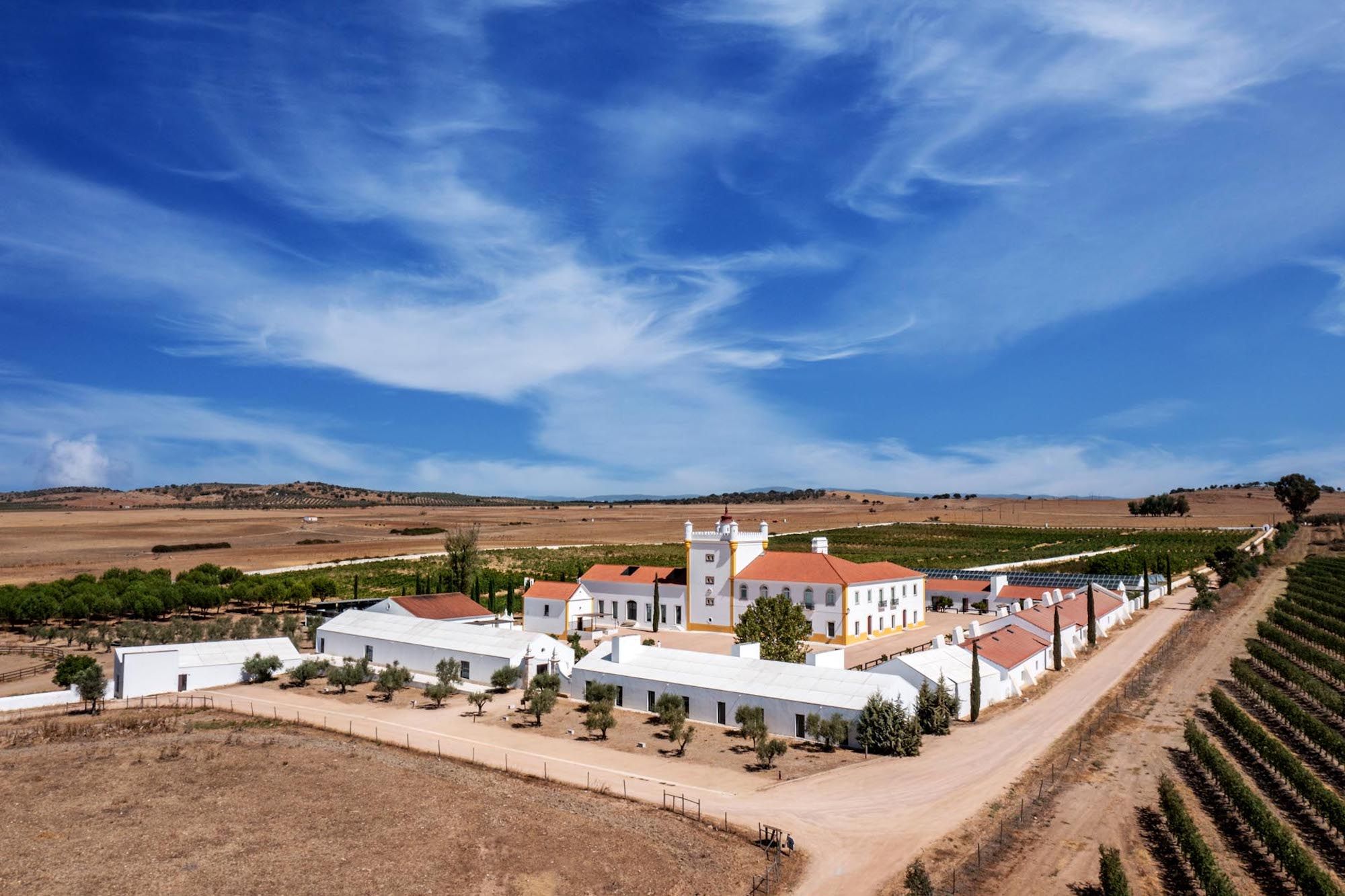 A white hotel amidst the scenic vineyards of Alentejo under bright skies for destination weddings in Portugal