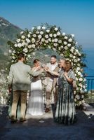 Bride and groom toast champagne glasses with their family members when they eloped in Italy