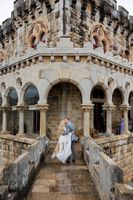 Newlyweds kiss in front of an arched opening of a castle after the ceremony of their destination wedding in Portugal