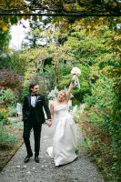 Bride and groom happily walking down a path surrounded by lush greens during their elopement in Ireland