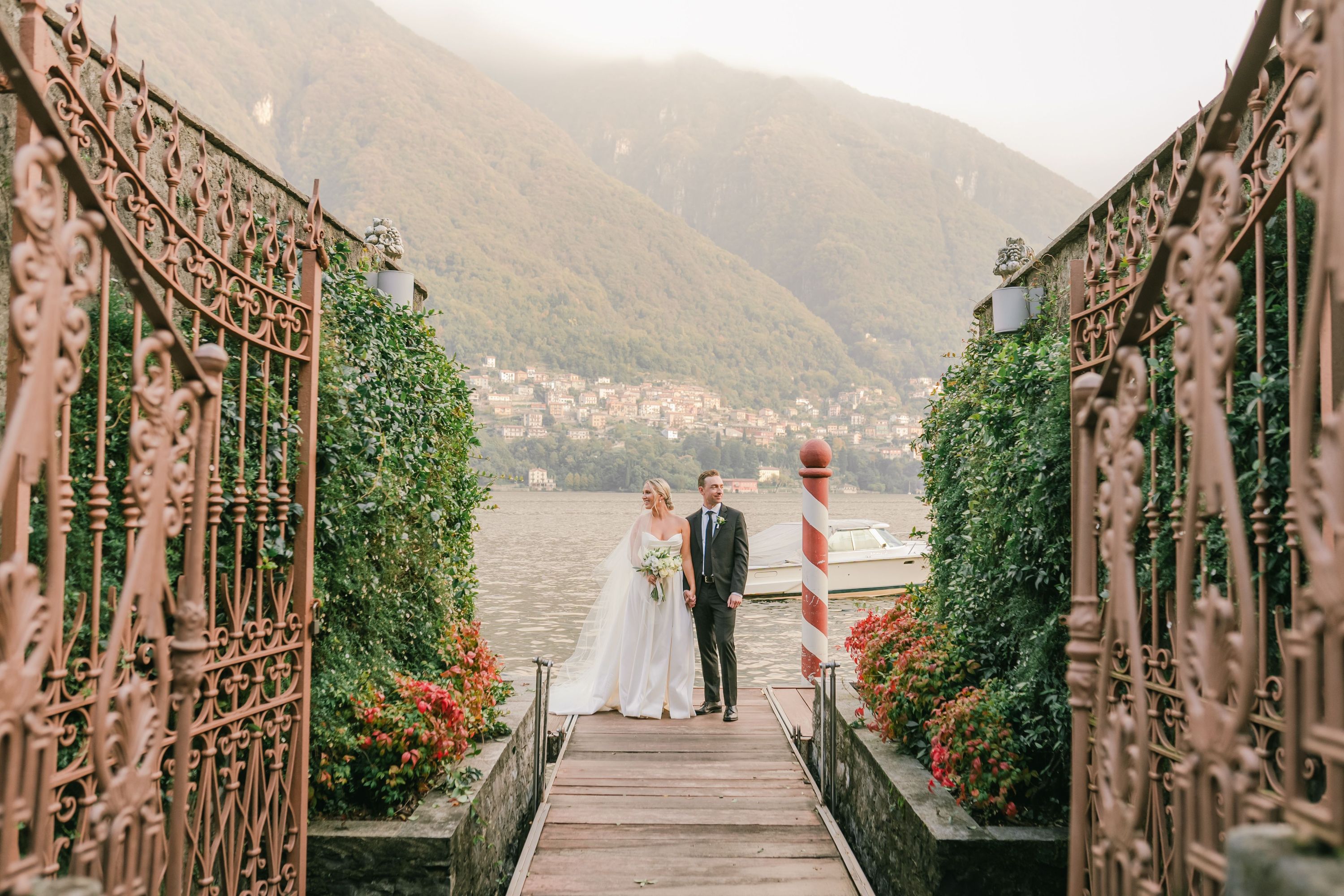 Bride and groom posing in front of ornate gates at their micro wedding in Italy