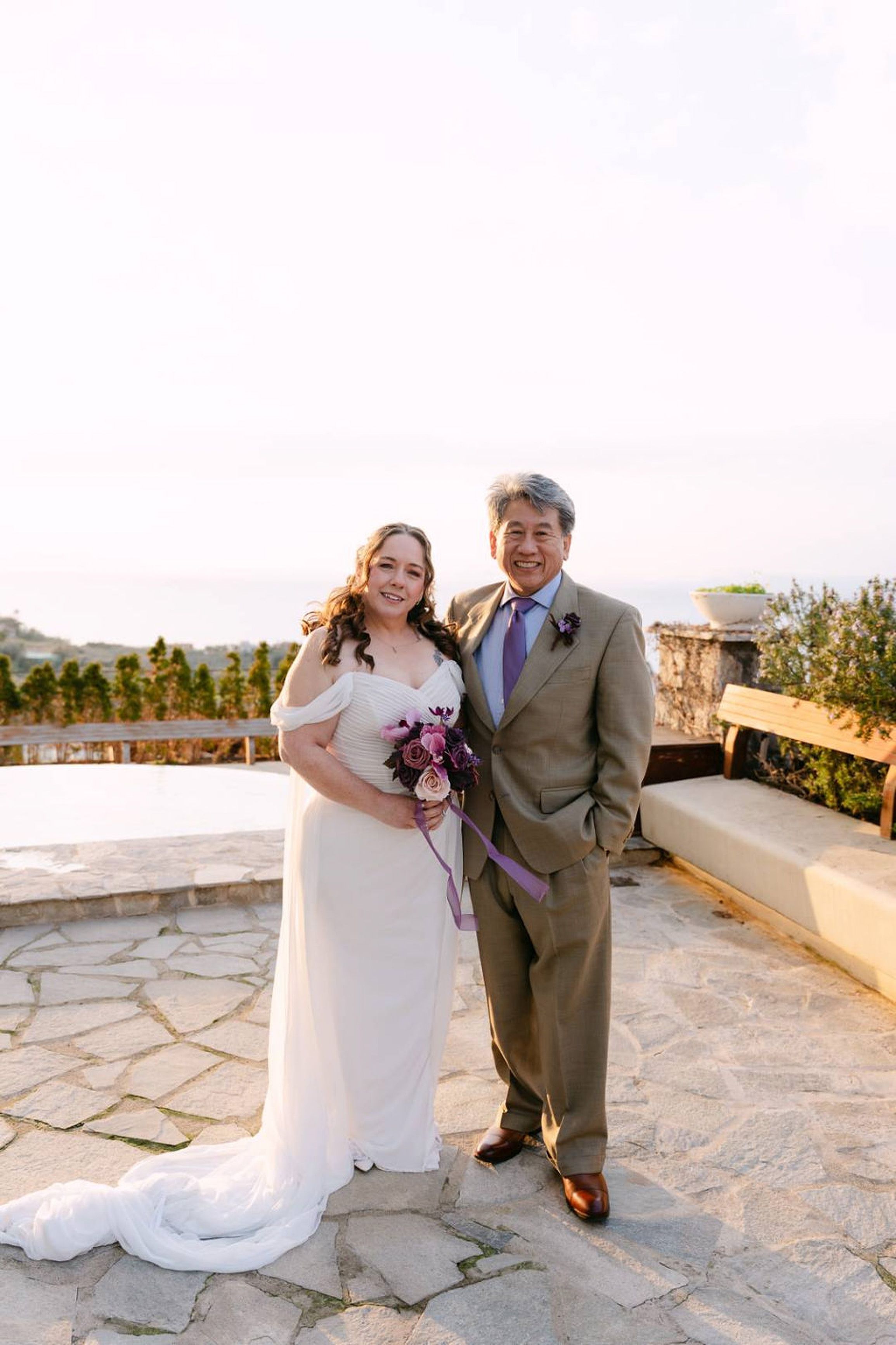 A couple during an intimate wedding in Italy on a terrace overlooking the coastline
